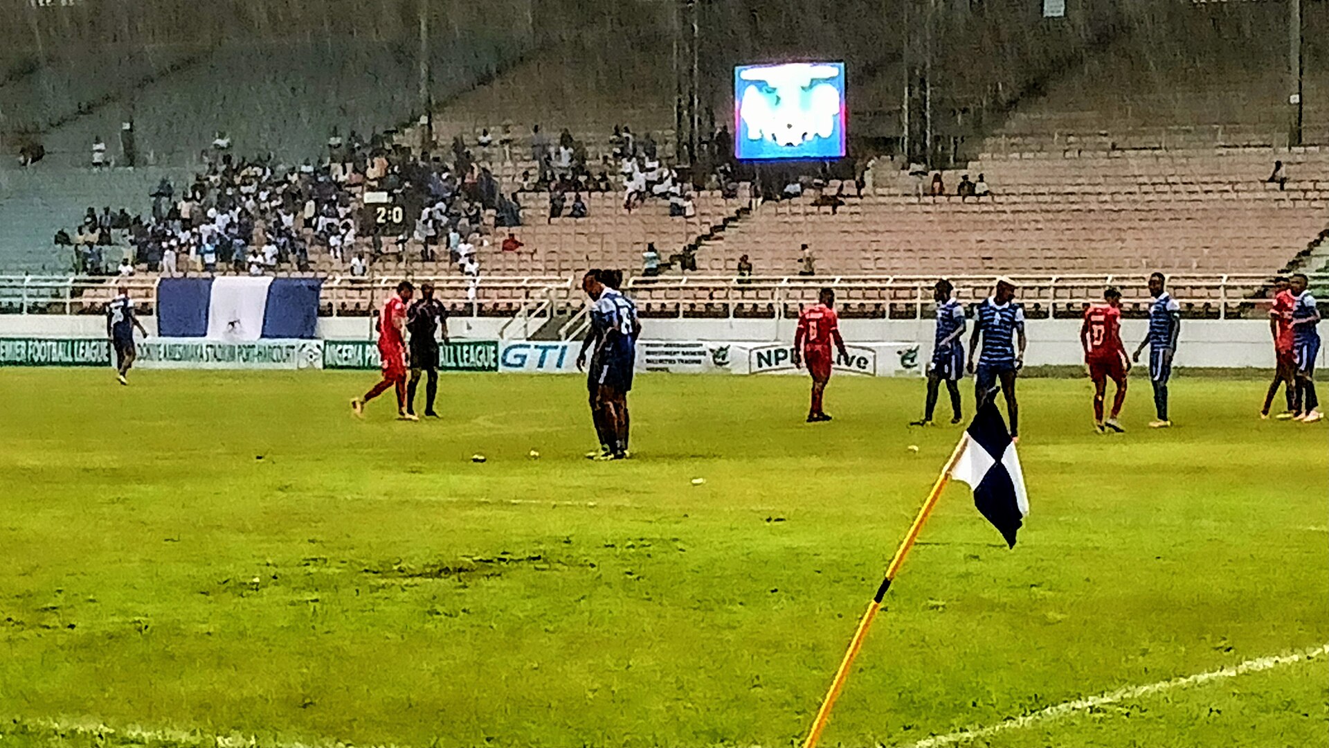 Joueurs de football disputant un match sous la pluie sur une pelouse détrempée